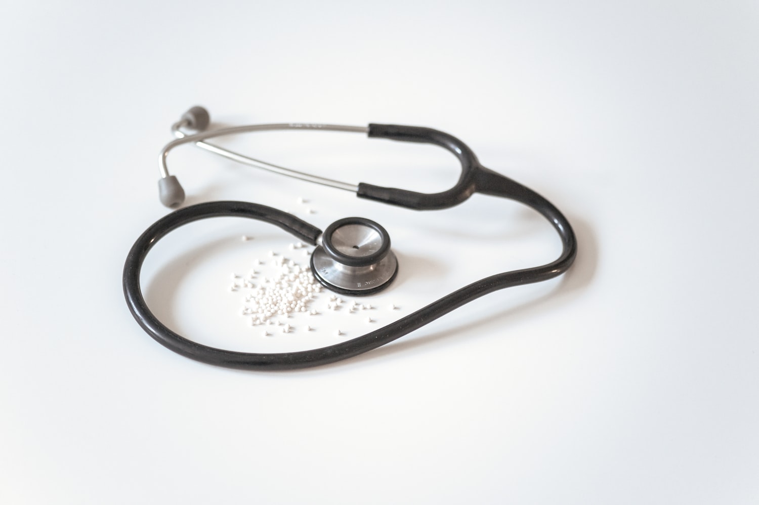 Minimal stethoscope and medication on a clean white surface