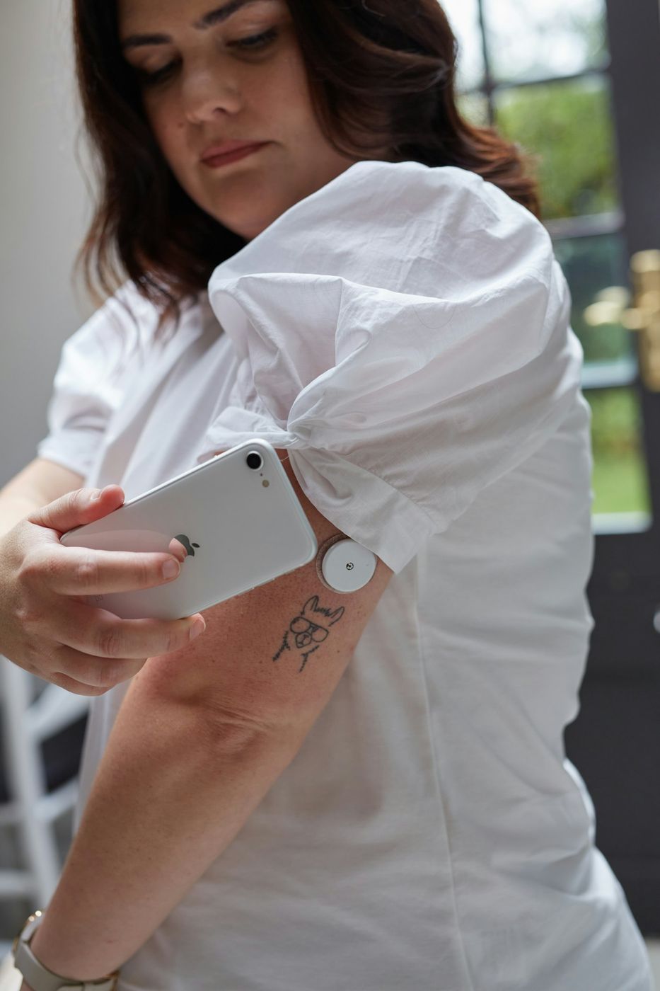 A person scanning a continuous glucose monitor sensor with a smartphone