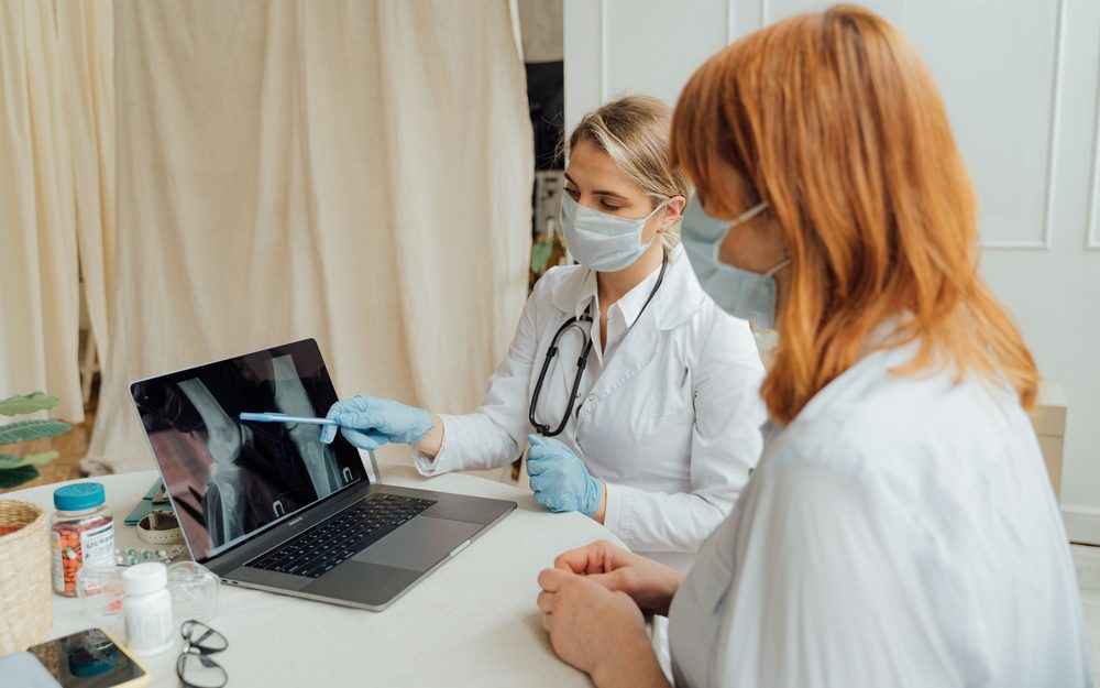 A doctor reviewing a knee X-ray with a patient